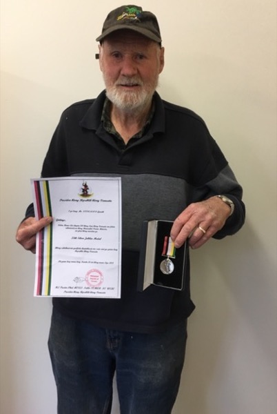 Garth Stevenson holding his certificate and medal from the Presbyterian Church of Vanuatu